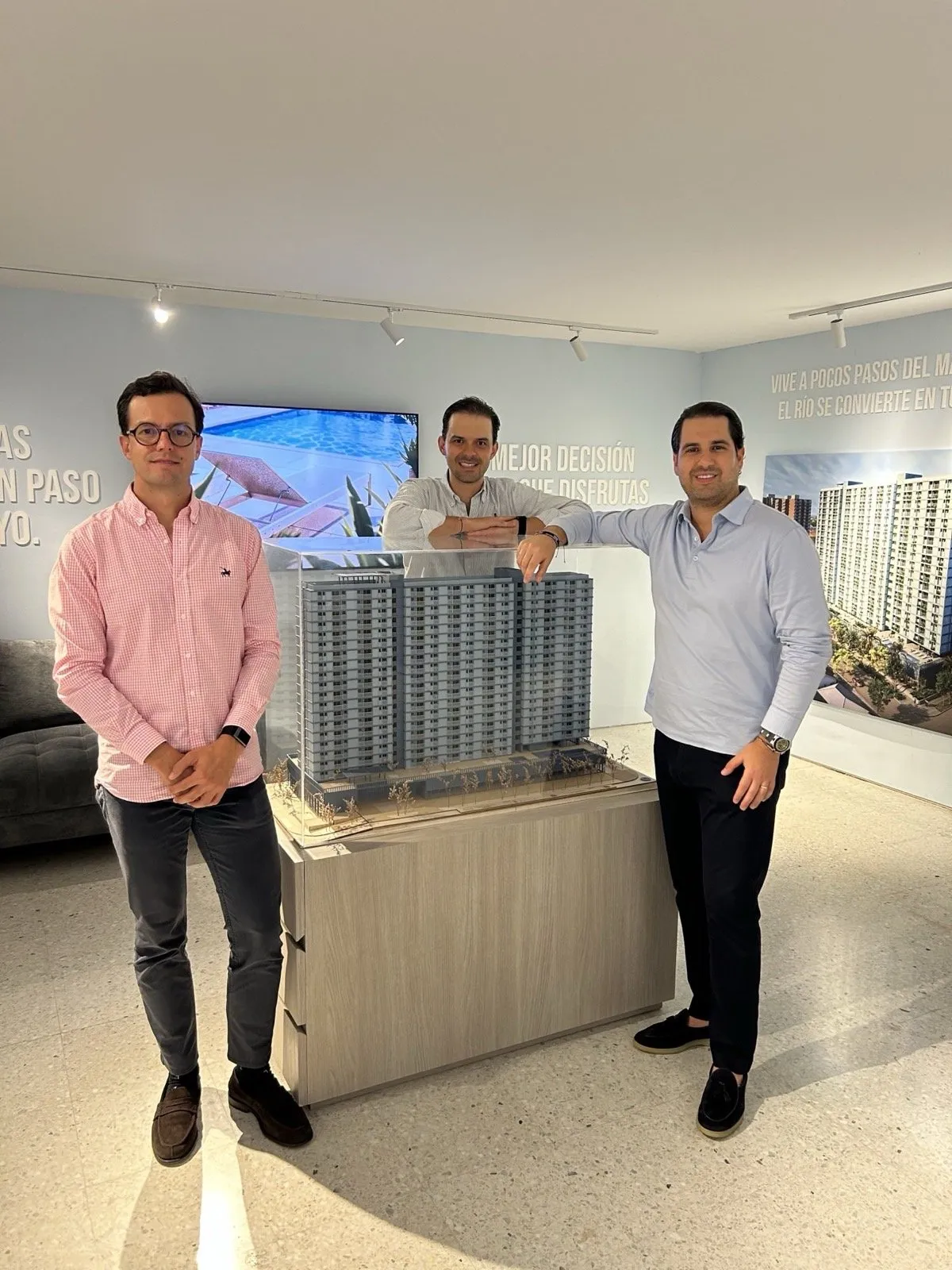 Equipos de Grupo Attia y MPF junto a la maqueta del proyecto en el showroom