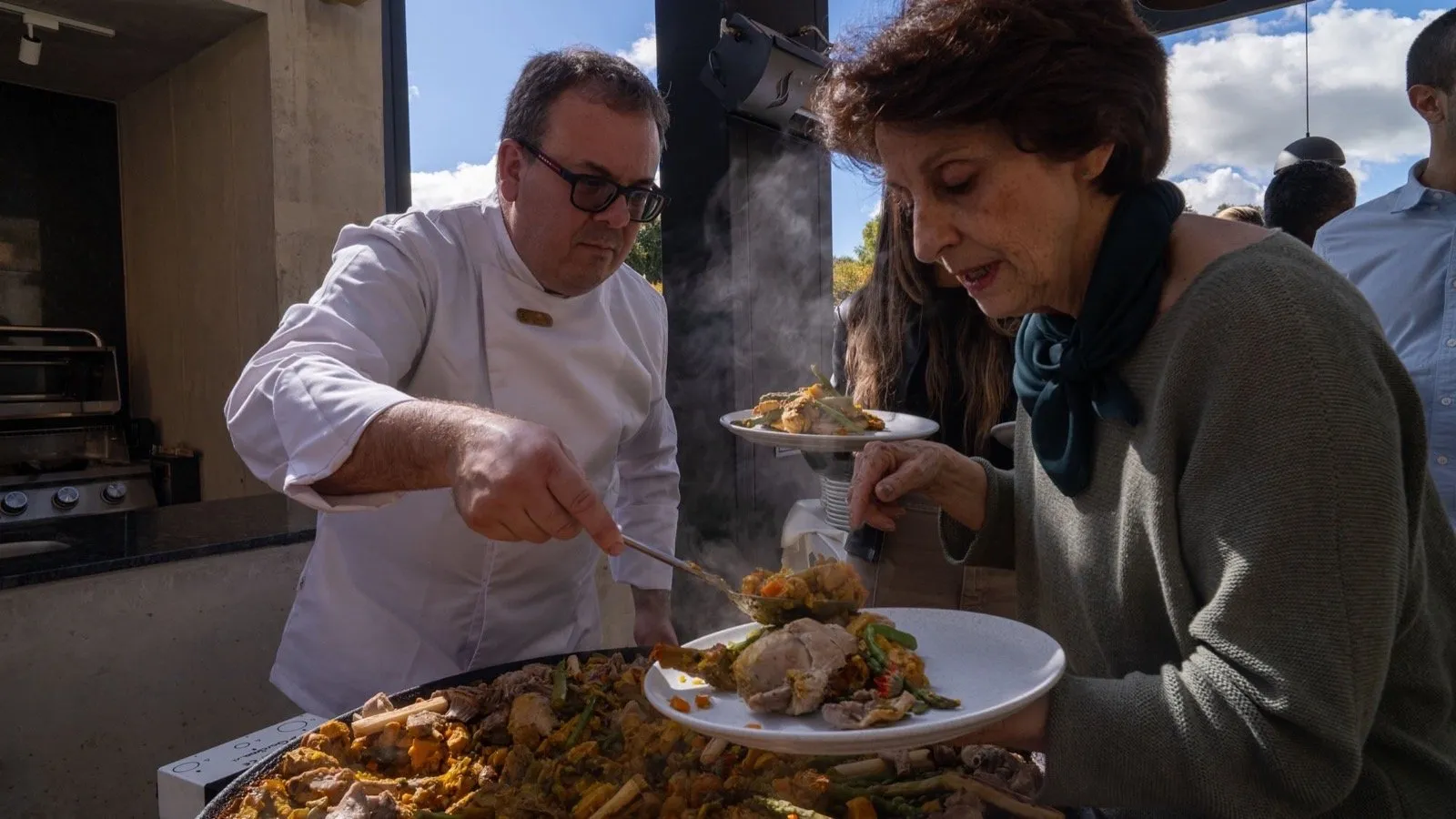 Chef sirviendo un plato durante el encuentro de comunidad