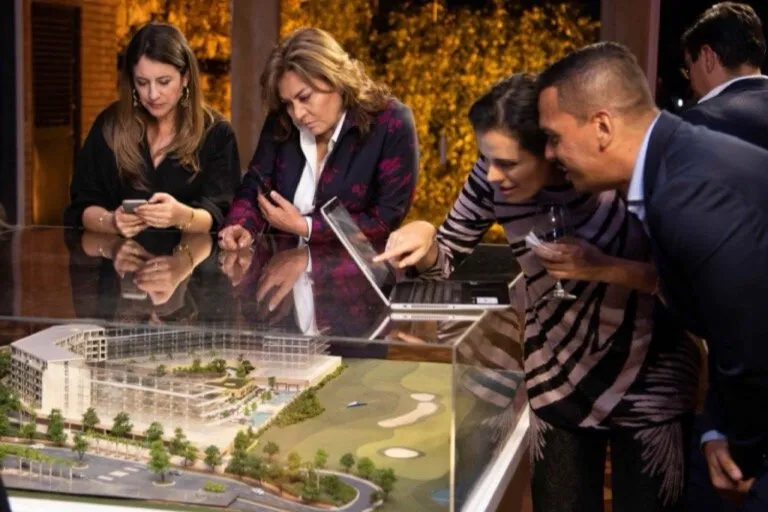 Invitados observando la maqueta del proyecto durante el encuentro con inversionistas